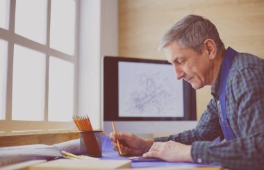 Ofisteki çizim masasında çalışan mimar