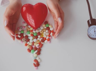 Masada kırmızı kalbi ve steteskopu olan kardiyolog.