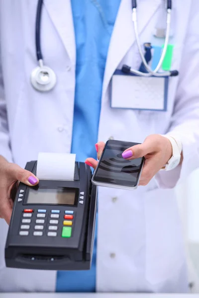 Le docteur tient le terminal de paiement entre les mains. Payer pour les soins de santé. Docteur. — Photo
