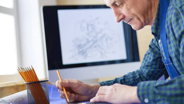 Архітектор, який працює над малюванням столу в офісі — стокове фото
