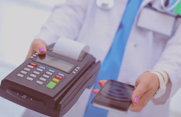Doktor drží platební terminál v rukou. Platit za zdravotní péči. Doktor — Stock fotografie