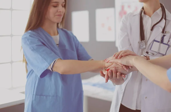 Artsen en verpleegkundigen in een medisch team stapelen handen — Stockfoto