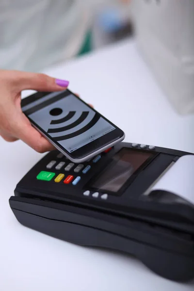 El cliente está pagando con el teléfono inteligente en la tienda utilizando la tecnología NFC. Tecnología NFC. Cliente está pagando —  Fotos de Stock