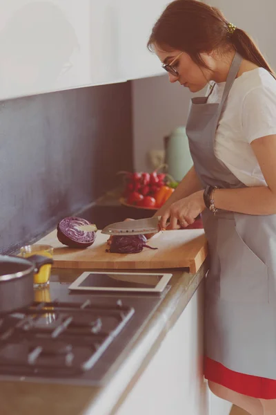 Vrouw koken in nieuwe keuken maken van gezond voedsel met groenten — Stockfoto