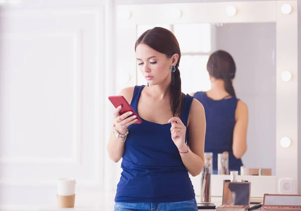 Salone di bellezza donna utilizzando e guardando il telefono cellulare — Foto Stock