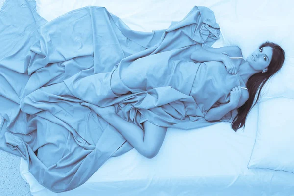 Красивая брюнетка лежит на кровати дома — стоковое фото