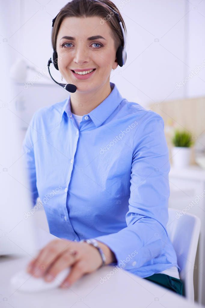 Serious pretty young woman working as support phone operator with headset in office