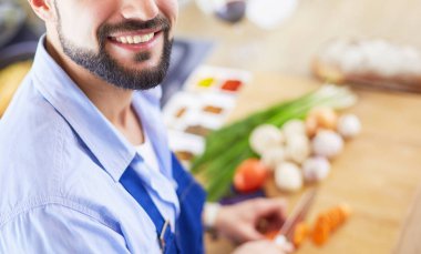 Adam ev mutfağında lezzetli ve sağlıklı yemekler hazırlıyor.