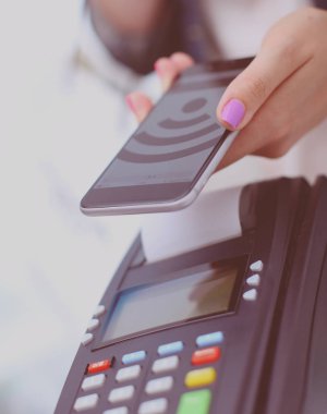 Müşteri ile smartphone Nfc teknolojisi kullanılarak dükkanda ödüyor. NFC teknolojisi. Müşteri ödeme