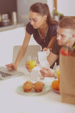 Çift evde mutfak içinde laptop ile onların fatura ödeme