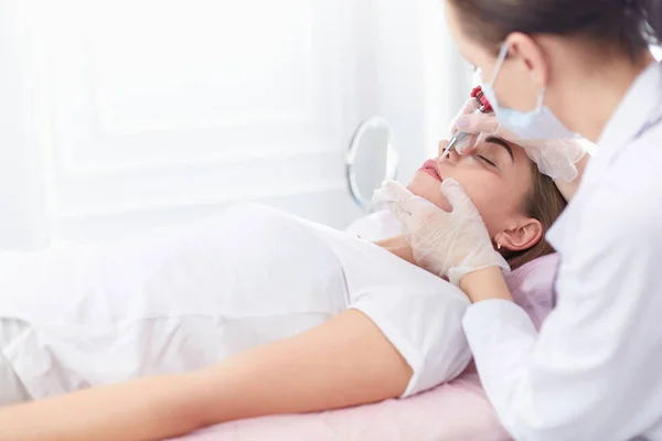 A young girl having red lips permanent makeup, micropigmentation — Stock Photo, Image