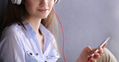 Katta oturan ve müzik dinleme genç mutlu kız