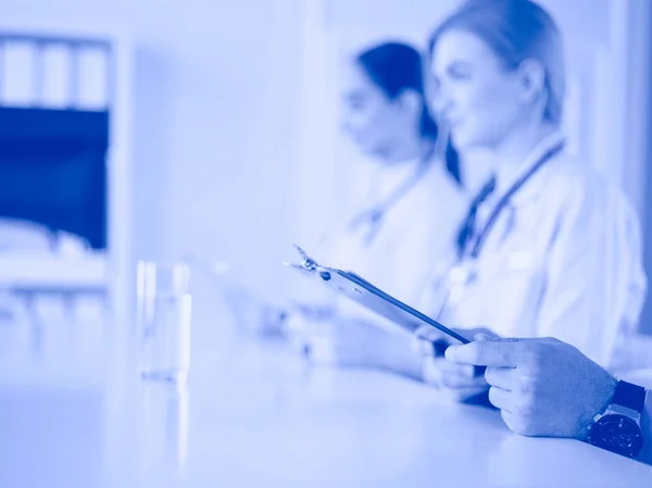 Doctors at the meeting, sitting on the desk — Stock Photo, Image