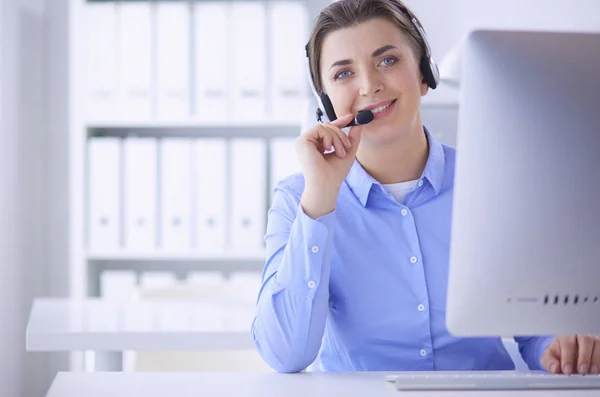 Vážná hezká mladá žena pracující jako podpora telefonního operátora se sluchátky v kanceláři — Stock fotografie