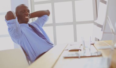 Kulaklıklı Afro-Amerikan işadamı laptopuyla çalışıyor.