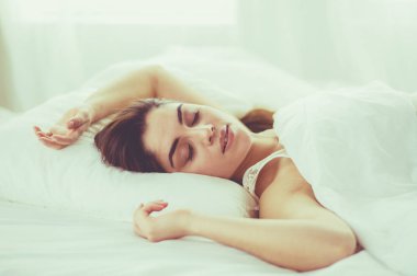 Güzel bir kadın yatağında uzanıyor.