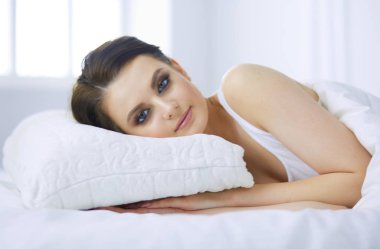 Genç ve güzel bir kadın yatakta yatıyor..