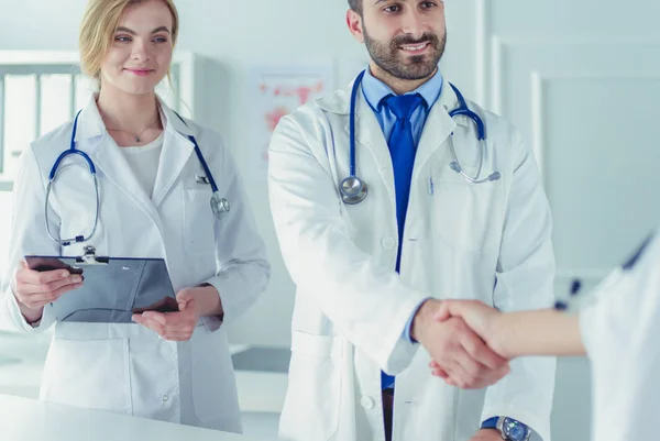 Una doctora le está mostrando a otro doctor una radiografía en su consultorio. —  Fotos de Stock