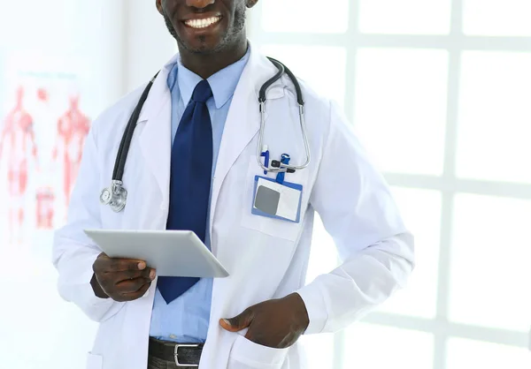 Male black doctor worker with tablet computer standing in hospital