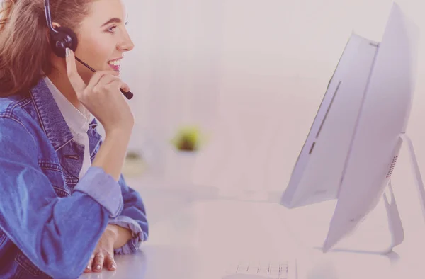 Retrato de mulher de negócios bonita trabalhando em sua mesa com fone de ouvido e laptop — Fotografia de Stock