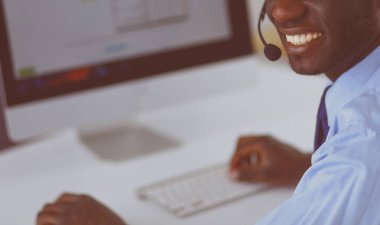 Kulaklıklı Afro-Amerikan işadamı laptopuyla çalışıyor.