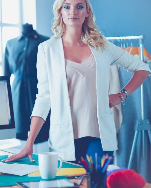 Moda tasarımcısı kadın stüdyoda tasarımları üzerinde çalışıyor..