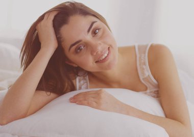 Güzel bir kadın yatağında uzanıyor.