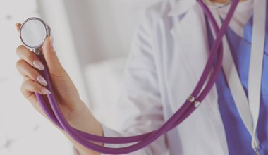 Hastanede steteskoplu gülümseyen doktor kadın.