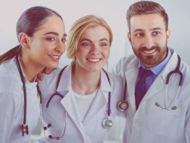 Başarılı tıbbi ekip. Kendine güvenen doktorlar bir arada durur ve gülümserler.