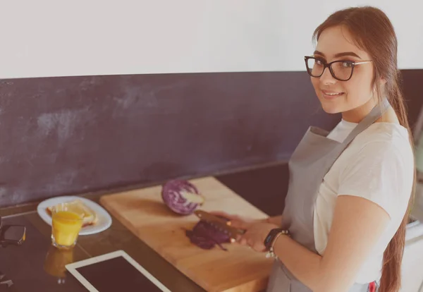 タブレットを使って台所で料理をする若い女性 — ストック写真