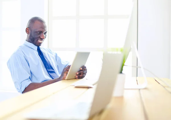 Hombre de negocios afroamericano con auriculares trabajando en su computadora portátil —  Fotos de Stock