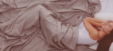 Evdeki yatakta uzanmış güzel esmer