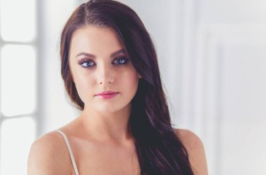 Evdeki yatakta uzanmış güzel esmer.