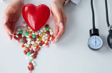 Masada kırmızı kalbi ve steteskopu olan kardiyolog.