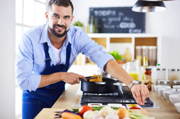 Adam ev mutfağında lezzetli ve sağlıklı yemekler hazırlıyor.