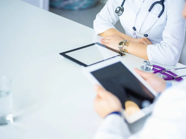 Équipe médicale assise et discutant à table — Photo