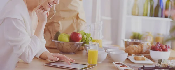 Hermosa joven usando una tableta digital en la cocina — Foto de Stock