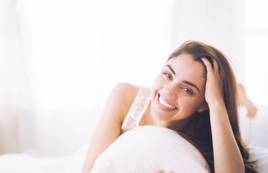 Güzel bir kadın yatağında uzanıyor.