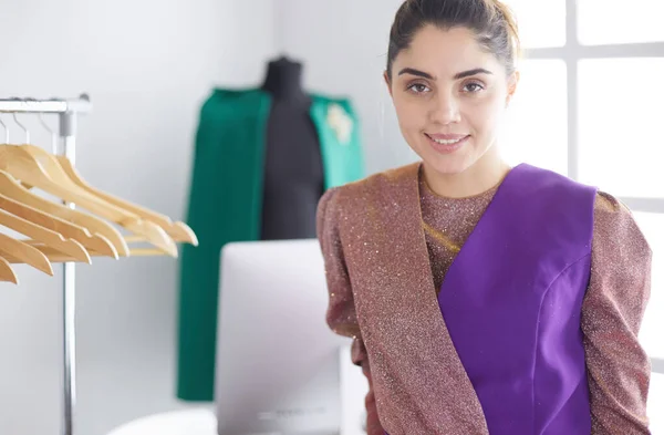 Mooie jonge stylist bij rek met hangers — Stockfoto