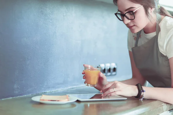 Portré fiatal vonzó fehér barna háziasszonyról a konyhában. Reggeli csésze kávé és tabletta pc — Stock Fotó