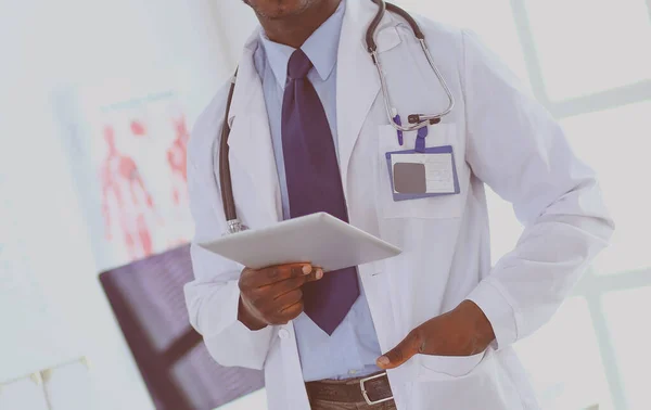 Male black doctor worker with tablet computer standing in hospital