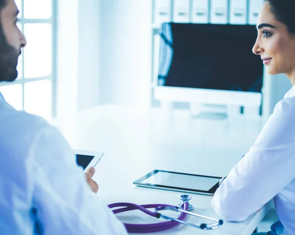 Equipe médica sentada e discutindo à mesa — Fotografia de Stock