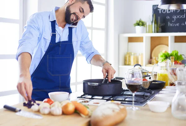 Uomo che prepara cibo delizioso e sano nella cucina di casa — Foto Stock