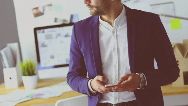 Junger Designer schreibt SMS in seinem Büro — Stockfoto