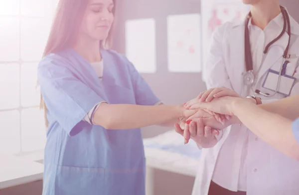 Läkare och sjuksköterskor i ett medicinskt team stapla händer — Stockfoto