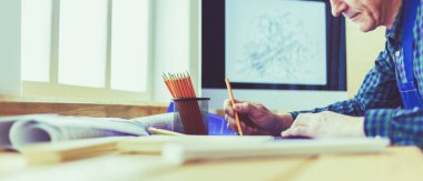 Ofisteki çizim masasında çalışan mimar