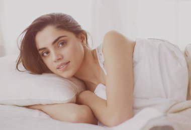 Güzel bir kadın yatağında uzanıyor.