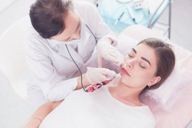 Kırmızı dudaklı genç bir kız kalıcı makyaj, mikro pigmentasyon