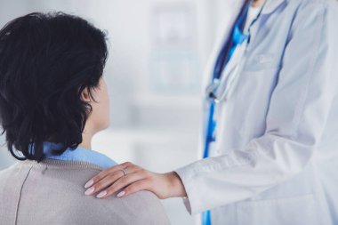 Kadın doktor bir hastaya danışmanlık yapıyor ve tıbbi bilgi ve teşhisi açıklıyor.