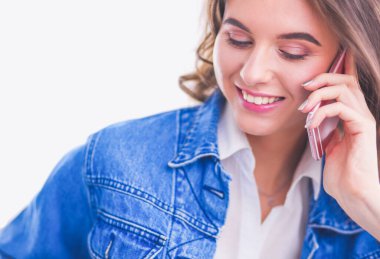 Kafede kahve içip cep telefonuyla konuşan genç bir kadın.